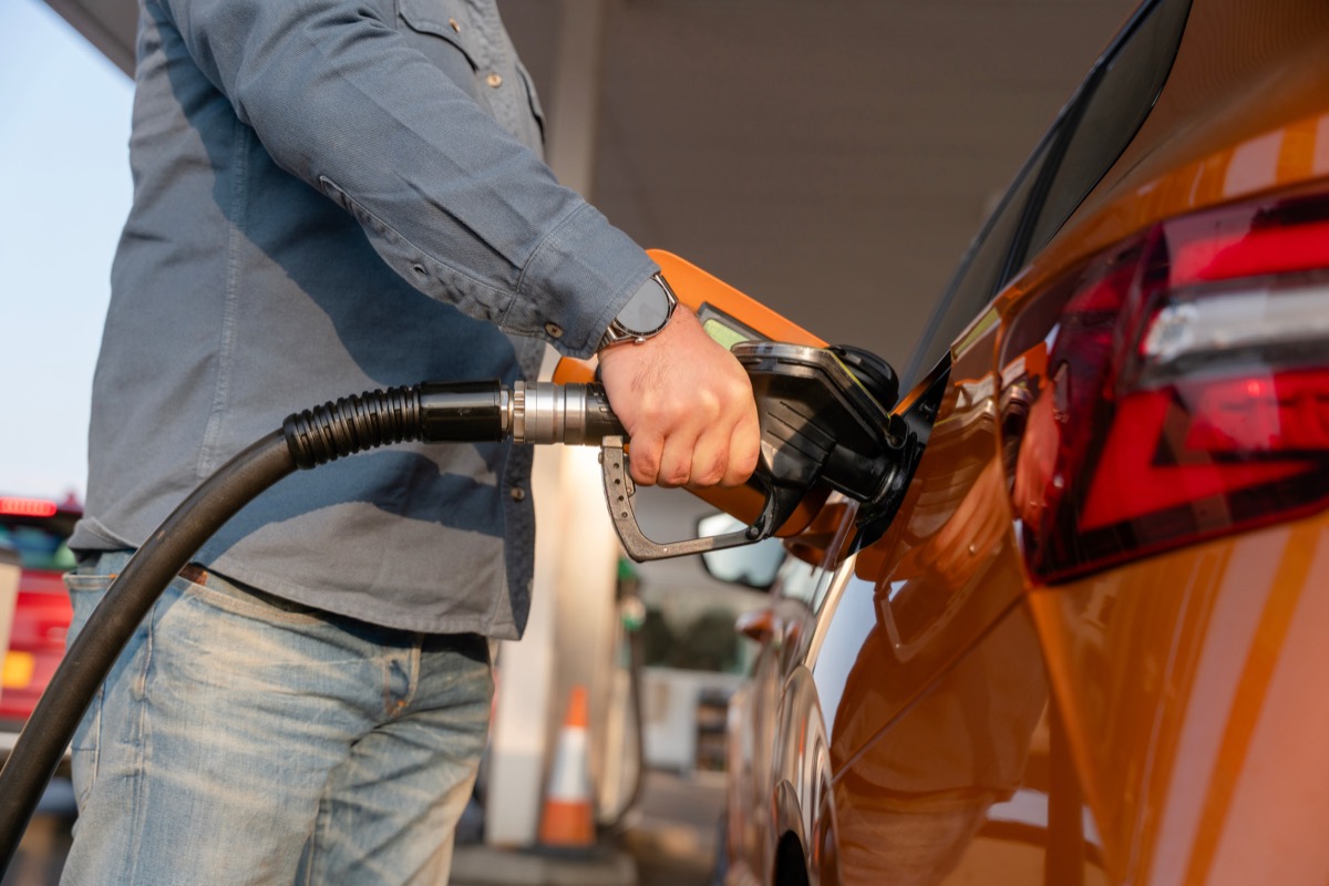 Une personne fait le plein de carburant dans une voiture.